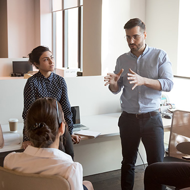 a group having a team coaching session in a computer centric office